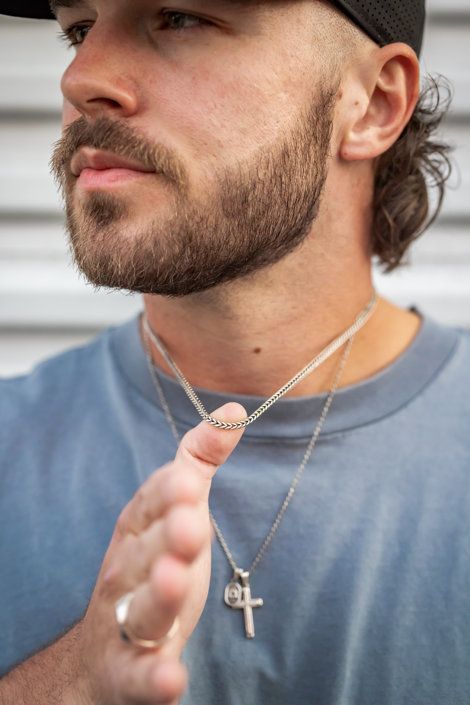 Model holding Darma silver franco chain necklace with cross pendant — men\u2019s jewelry lifestyle photography by Murrieta Media